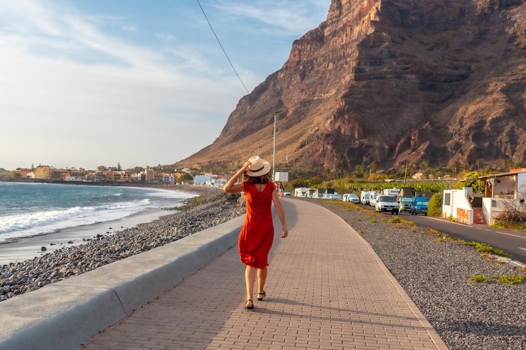 Foto mujer turista al atardecer caminando por la playa de la localidad de valle gran rey en la gomera islas canarias