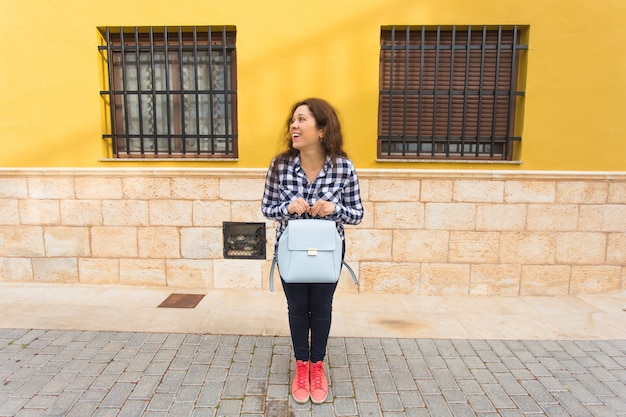 La mujer turista asombrada divertida del viajero en ropa casual sostiene el bolso. Estilo de vida de viaje turístico.