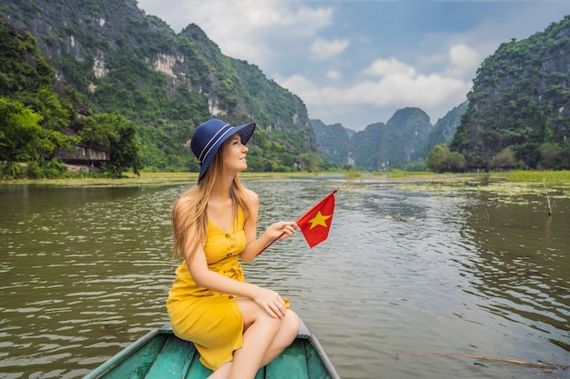 Mujer turista en barco por el lago tam coc ninh binh viet nam es sitio del patrimonio mundial de la unesco