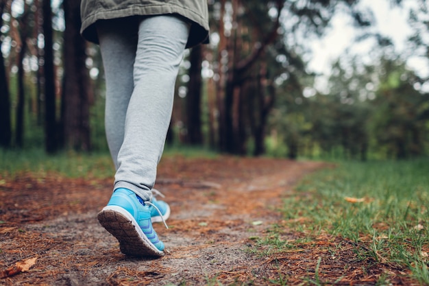 Mujer turista caminando en bosque primaveral Cierre de zapatos Viajes y turismo