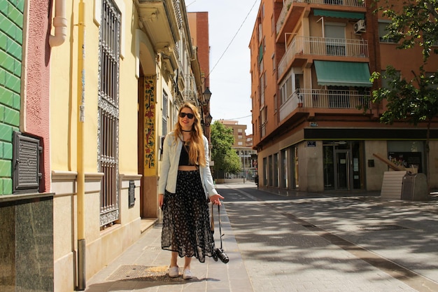 Mujer turista caminando en la calle con una cámara