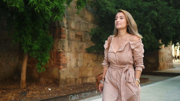 Mujer turista caminando por la calle de la ciudad vieja Chica bronceada mirando turismo