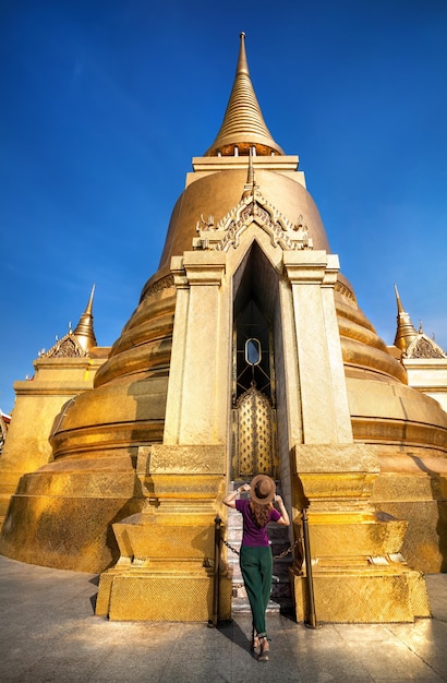 Foto mujer turista cerca de la estupa dorada en tailandia