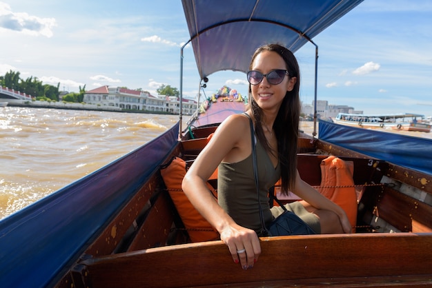 Mujer turista explorando la ciudad de Bangkok con barco fluvial