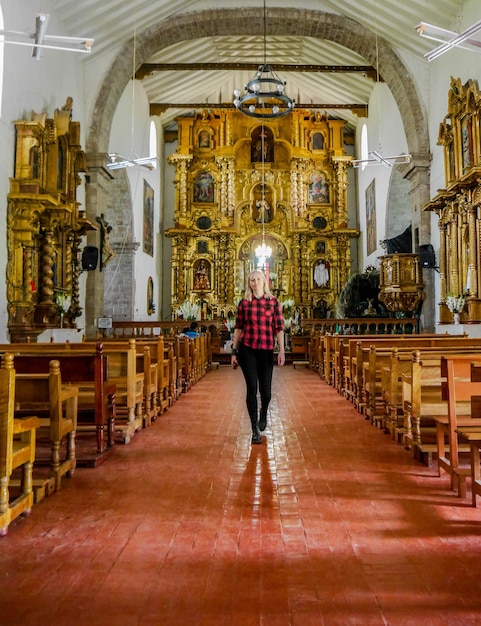 Mujer turista en la Iglesia de Yucay en el Valle Sagrado de los Incas en la ciudad de Cusco