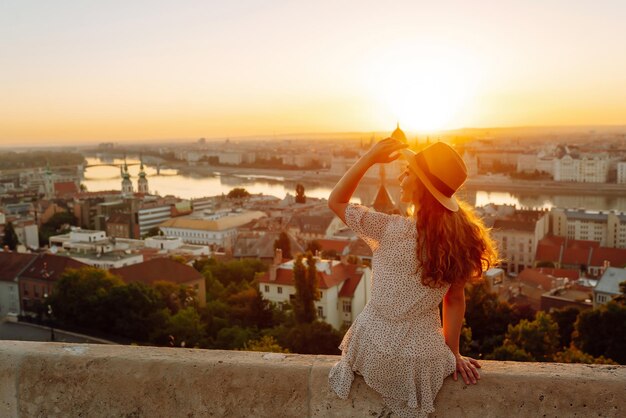 Mujer turista joven mirando la vista panorámica de la ciudad al atardecer Estilo de vida viajes vida activa