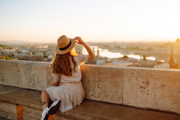 Mujer turista joven mirando la vista panorámica de la ciudad al atardecer Estilo de vida viajes vida activa