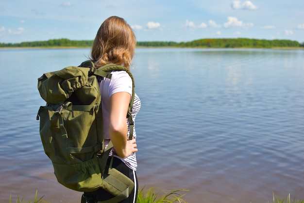 mujer turista en el lago con una mochila