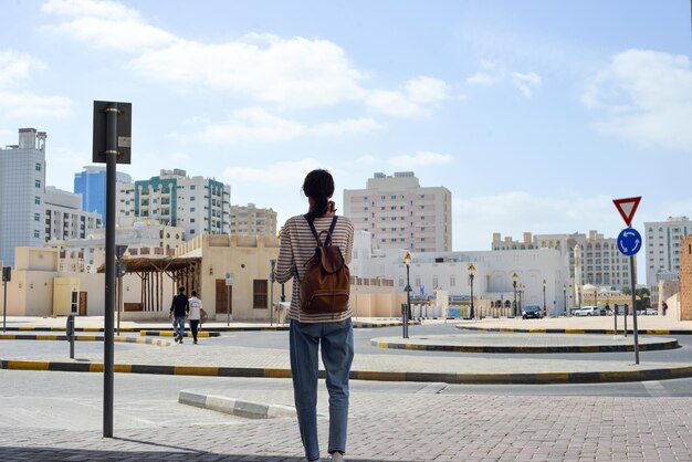 Mujer turista con mochila en las calles árabes en la parte antigua de Sharjah, Emiratos Árabes Unidos