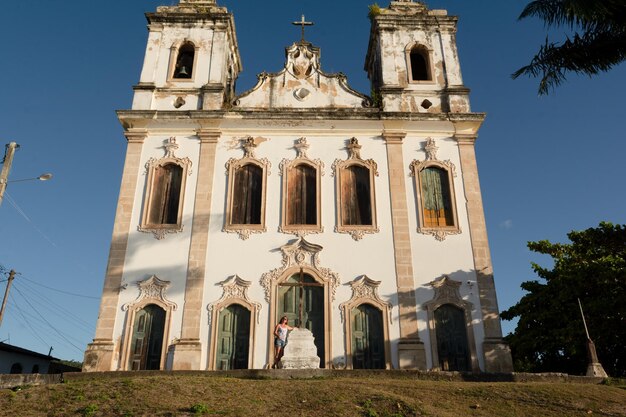 Mujer turista de pie frente a la iglesia de Santiago do Iguape en la ciudad de Cachoeira Bahia