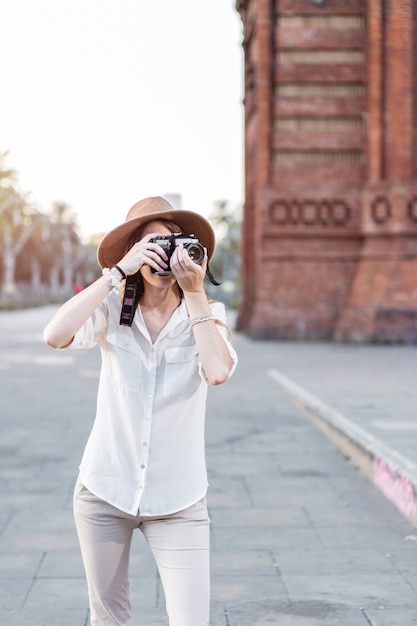 Mujer turista que viaja con una cámara. Viajera caminando por las calles de Barcelona tomando fotografías