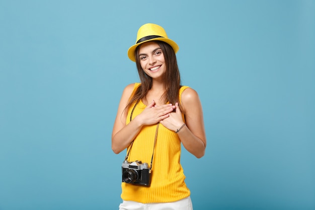 Mujer turista en ropa casual de verano amarillo y sombrero con cámara de fotos en azul