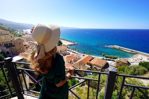 Mujer turista con sombrero disfrutando de la vista en Pizzo Calabro Italia