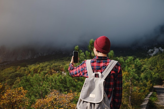 Mujer turista tomando fotos por teléfono inteligente en viajes de montaña