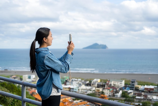 Mujer turista usa su teléfono móvil para tomarse una foto en Yilan, Taiwán