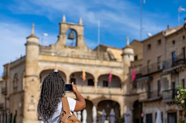 Foto mujer turista de vacaciones tomando fotos con teléfono en el famoso pueblo de ciudad rodrigo en salamanca