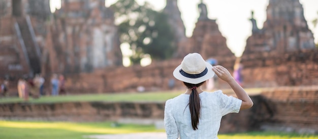 Mujer turista vestida de blanco visitando la antigua estupa en el templo Wat Chaiwatthanaram en el Parque Histórico de Ayutthaya, concepto de viaje de verano, Asia y Tailandia