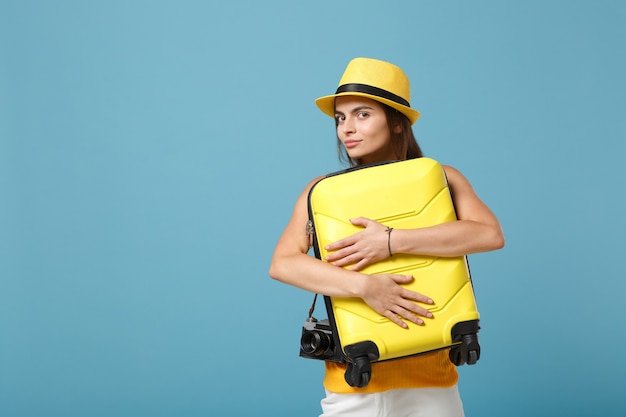 Mujer turista viajero en ropa casual amarilla, sombrero con cámara de fotos maleta en azul