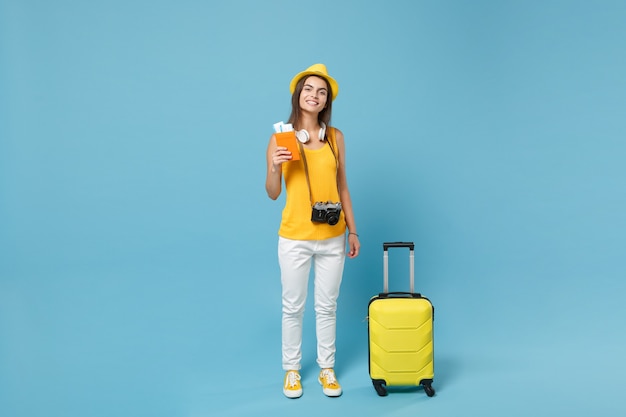 Mujer turista viajero en sombrero de ropa casual de verano amarillo con cámara de bolsa de boletos en azul