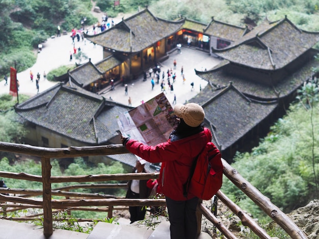 Mujer turística asiática que mira al mapa la ciudad en Chongqing, China.