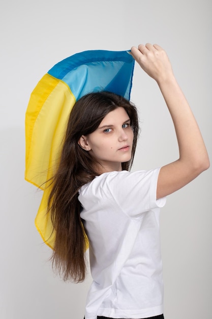 Mujer ucraniana con bandera ucraniana azul y amarilla sobre fondo blanco aislado El símbolo de la inviolabilidad del pueblo ucraniano Detener la guerra Esperanza y fe