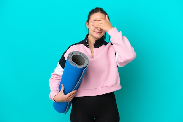 Mujer ucraniana deportiva que va a clases de yoga mientras sostiene una alfombra que cubre los ojos con las manos No quiere ver algo