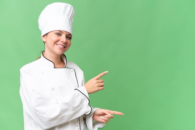 Una mujer con uniforme de chef señala una pantalla verde