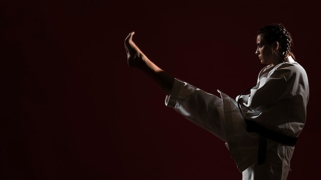 Mujer en uniforme de karate blanco y copia espacio de fondo