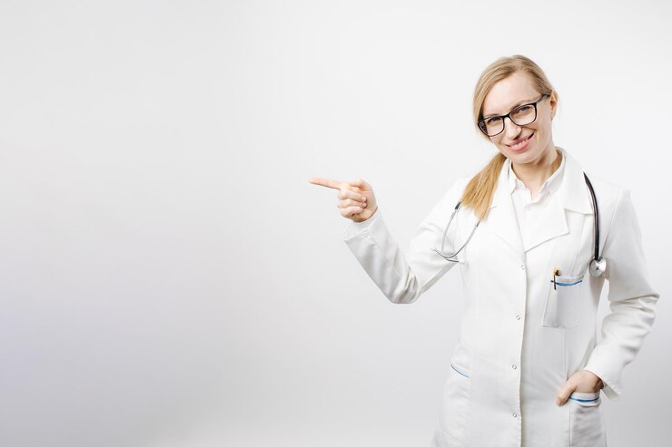 Mujer con uniforme médico apuntando con el dedo al espacio vacío
