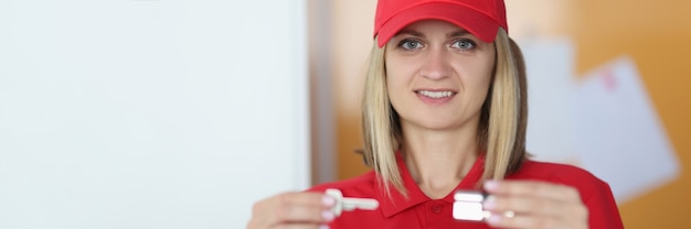 Mujer en uniforme rojo tiene una llave y candado en sus manos.