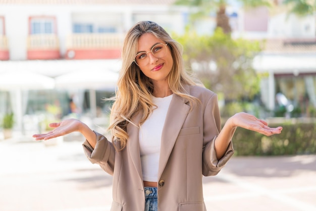 Mujer uruguaya bastante rubia con gafas al aire libre sonriendo