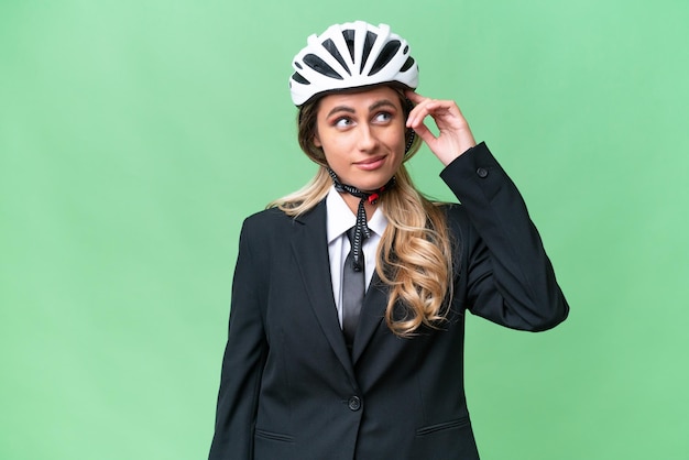 Mujer uruguaya de negocios que lleva un casco de motociclista sobre un fondo aislado que tiene dudas y con una expresión facial confusa