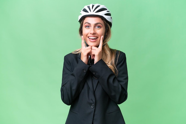 Mujer uruguaya de negocios que lleva un casco de motociclista sobre un fondo aislado sonriendo con una expresión feliz y agradable