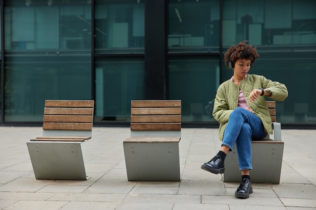 La mujer usa la aplicación en el reloj inteligente moderno para organizar el tiempo verificado La notificación recibida usa un dispositivo portátil escucha música en auriculares