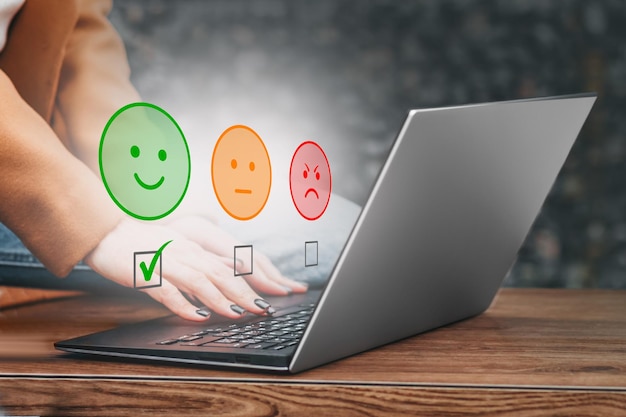 La mujer usa la computadora portátil eligiendo el concepto de salud mental del icono de la cara de sonrisa feliz verde