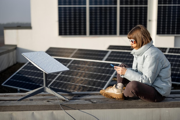 Mujer usa internet starlink en techo con paneles solares