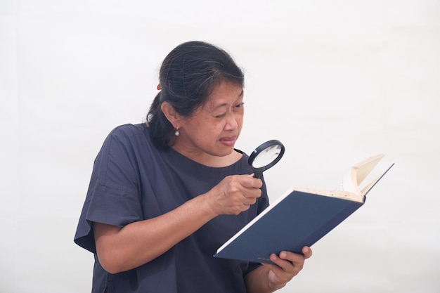 Foto una mujer usa una lupa para leer