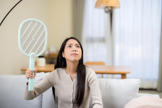 La mujer usa un matador de mosquitos en casa.