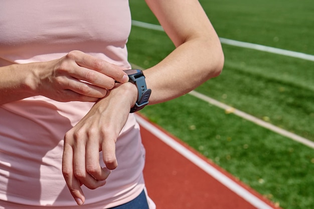 La mujer usa un reloj inteligente de fitness comprobando los resultados después del entrenamiento deportivo