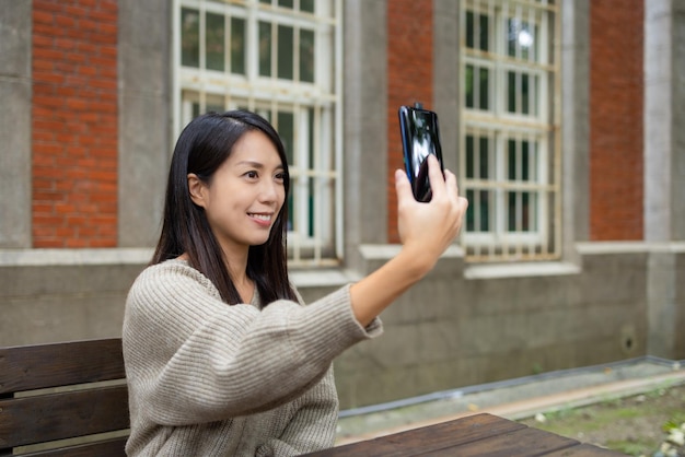 Mujer usa teléfono celular para hacerse una selfie