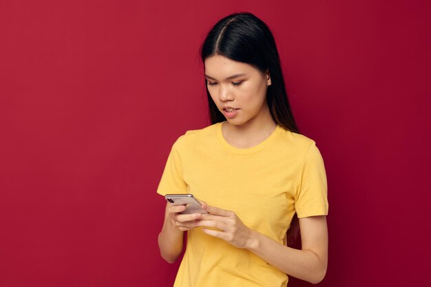 La mujer usa el teléfono con un fondo rojo