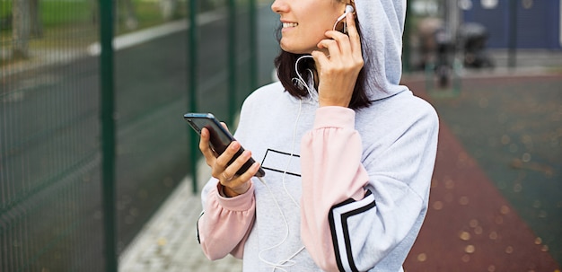 mujer usa un teléfono inteligente para escuchar música