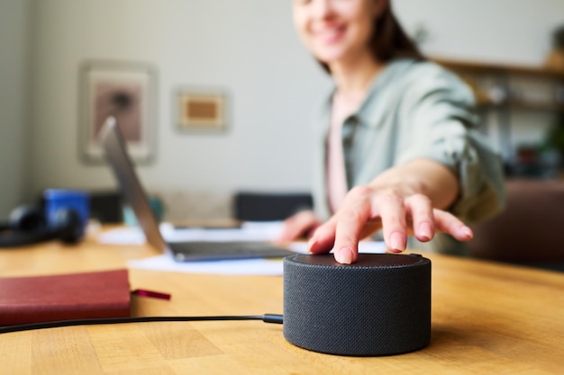 Foto mujer usando altavoz inteligente en casa