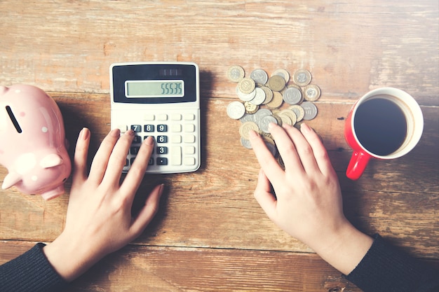 Mujer usando calculadora y contando monedas