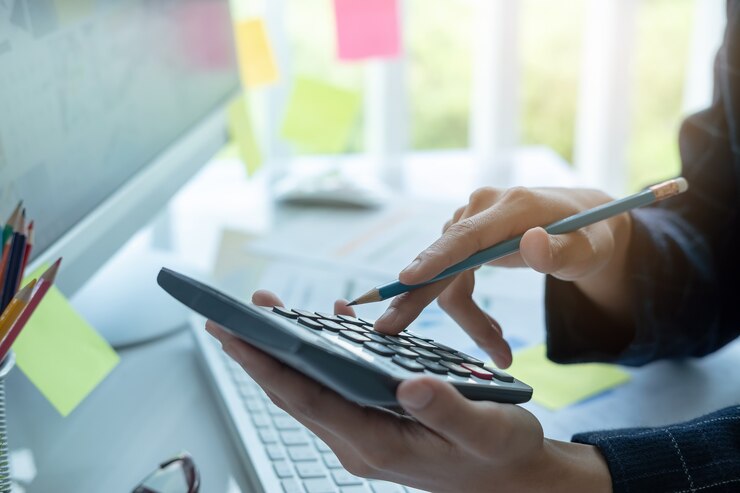 Foto mujer usando calculadora mientras trabaja para documentos financieros