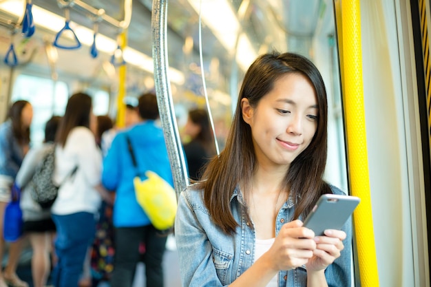 Mujer usando celular dentro del compartimiento del tren