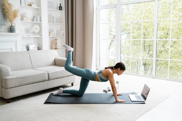 Mujer usando una colchoneta de fitness para hacer ejercicio