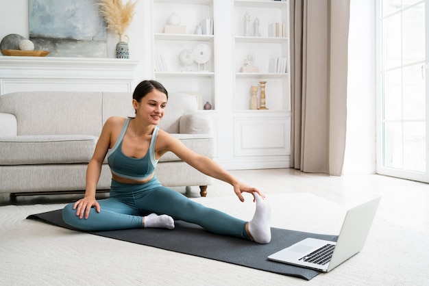 Foto mujer usando una colchoneta de fitness para hacer ejercicio