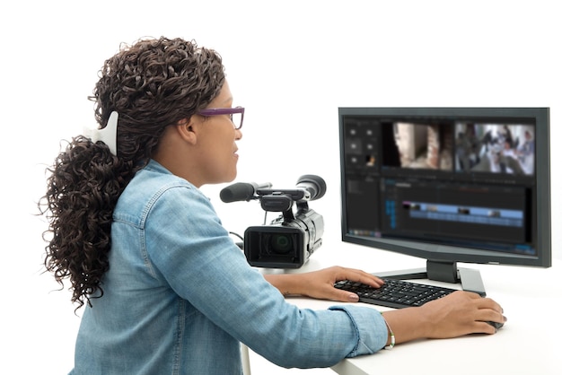 Foto mujer usando una computadora con una cámara de cine contra un fondo blanco