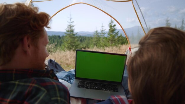 Foto una mujer está usando una computadora portátil en una carpa con una pantalla verde.